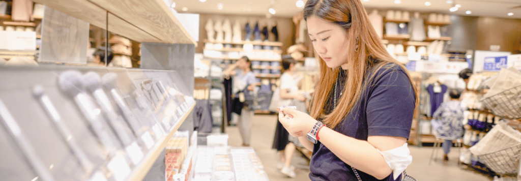 Woman looking at lipstick at beauty retailer